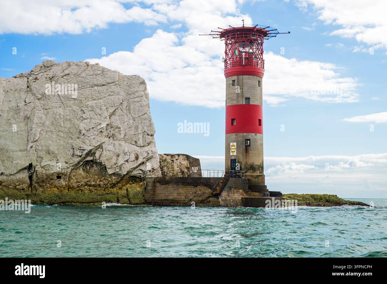 Le phare des Needles de 33 mètres (80 pieds) de haut, situé sur la pile de craie la plus extérieure des trois piles connues sous le nom de The Needles, sur l'île de Wight, en Angleterre Banque D'Images