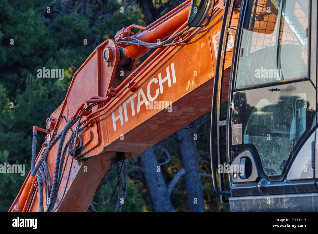 Orebic, Croatie – 20 mai 2026 : Gros plan d’un bras de pelleteuse Hitachi orange vif montrant les tuyaux hydrauliques, les joints métalliques et l’usure sur une machine de construction lourde Banque D'Images