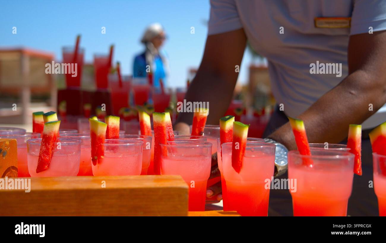 Barman préparant des cocktails tropicaux à la pastèque frais dans un bar de resort en bord de plage. Banque D'Images