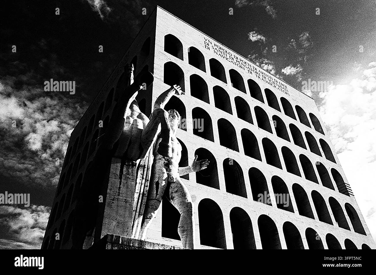 Bâtiment avec sculptures sous un ciel nuageux dans une vue en noir et blanc Banque D'Images