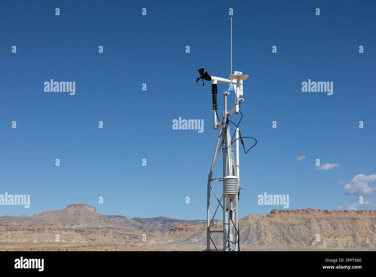 gros plan d'une station de surveillance météorologique extérieure avec un capteur de vent et d'autres instruments météorologiques montés sur une tour métallique, sur fond de ciel dégagé Banque D'Images