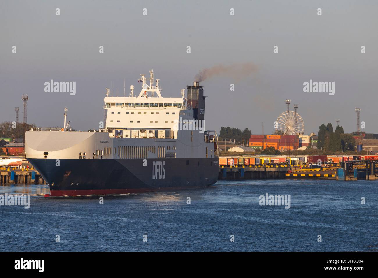 Harwich, Angleterre, 25 août 2026 : Un grand ferry DFDS quitte le port de Harwich au Royaume-Uni, avançant dans des eaux calmes devant les terminaux de conteneurs Banque D'Images