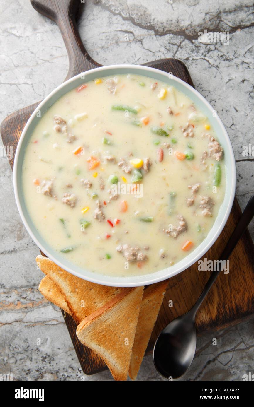 La soupe crémeuse au Shepherd's Pie est préparée avec une purée de pommes de terre traditionnelle, du fromage, de la viande hachée et des légumes en gros plan sur l'assiette sur la table. Vertical t Banque D'Images