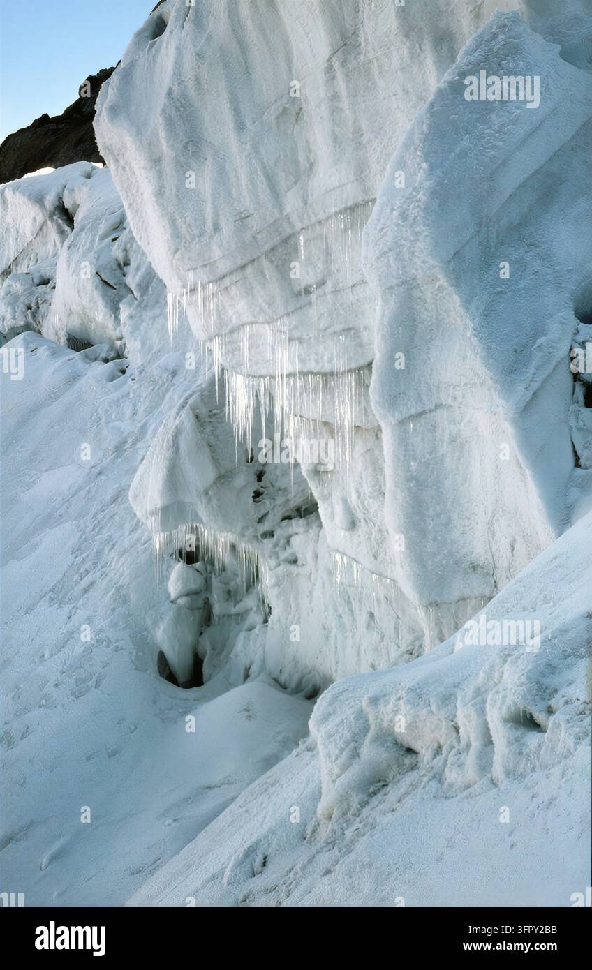Vue rapprochée d'une paroi glaciaire avec des formations d'ice complexes et des stalactites de glace pendantes. La scène met en valeur les textures et les motifs créés par le gel Banque D'Images