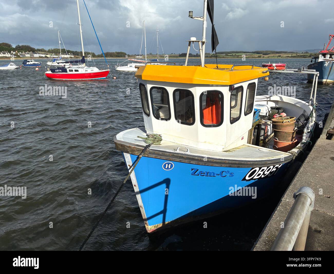 Port de Garlieston à Wigtownshire (Dumfries et Galloway) – des bateaux et des yachts colorés sous le soleil avec des nuages à averses derrière – octobre 2026 - Image de stock capturée avec un smartphone