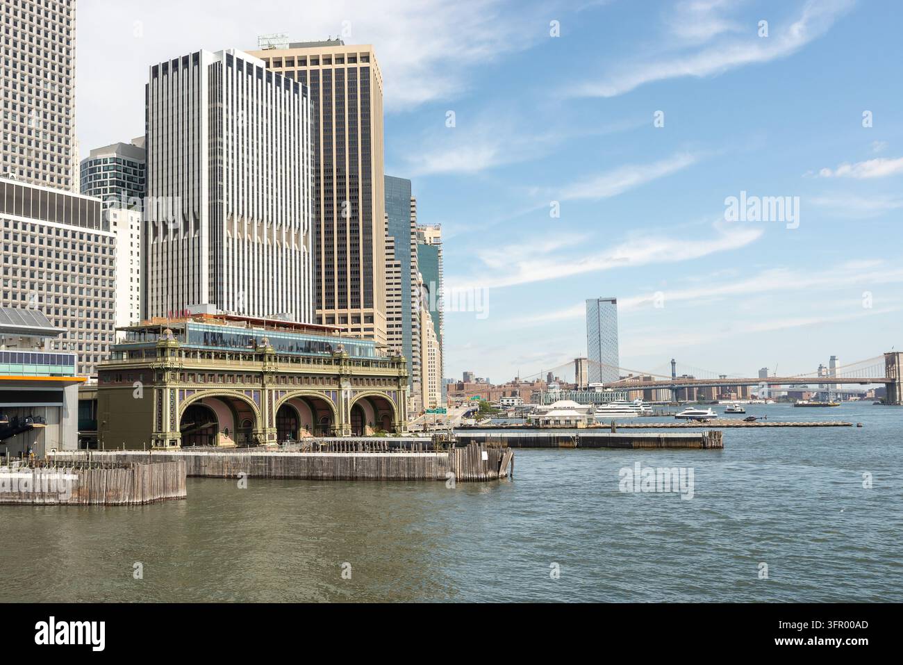 Le terminal de ferry de Lower Manhattan vu depuis l'eau à New York, avec le pont de Brooklyn visible en arrière-plan. La scène du front de mer ca Banque D'Images