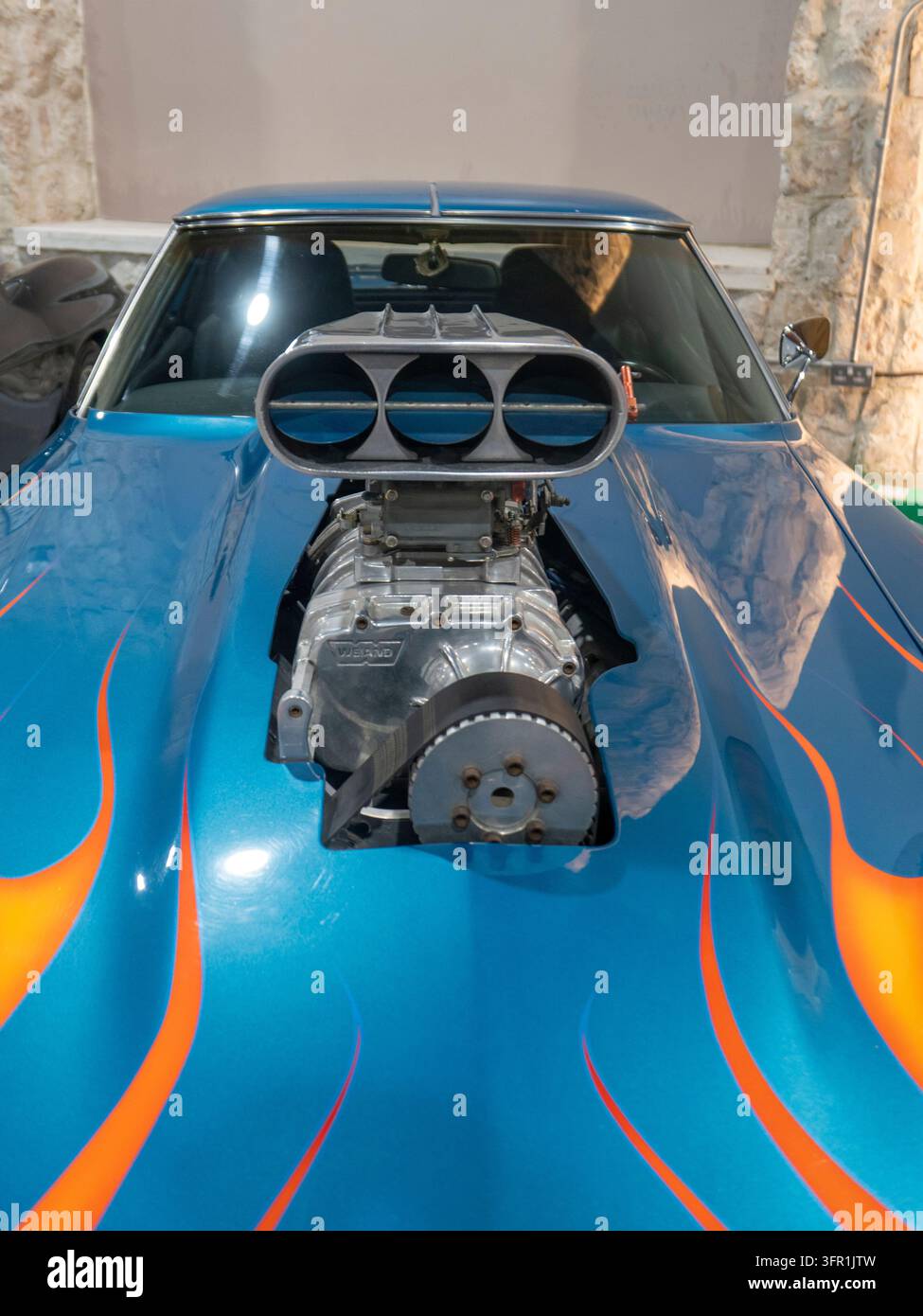 Vue rapprochée de face d'une voiture Hot rod bleue classique dotée d'un compresseur superchargeur Weiand chromé proéminent et de flammes orange. Banque D'Images