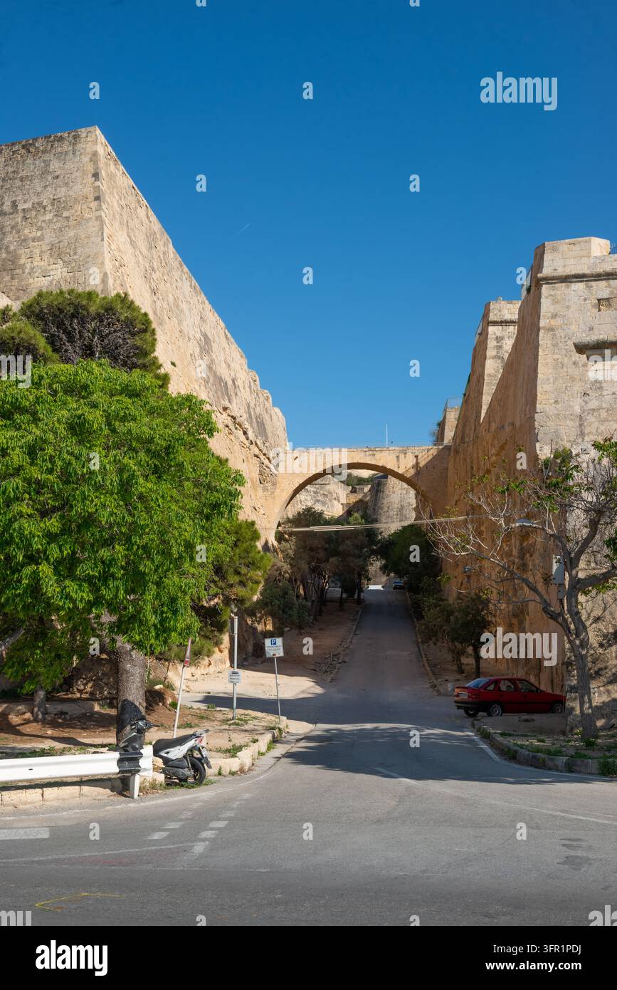 Route traversant les imposantes murailles de fortification en calcaire et le pont en pierre du Fort Saint-Elme à La Valette, Malte Banque D'Images