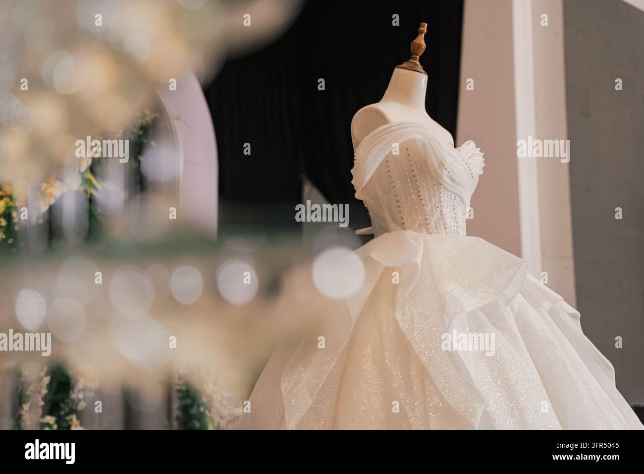Robe de mariée blanche étincelante élégante sur un mannequin avec un premier plan flou Banque D'Images