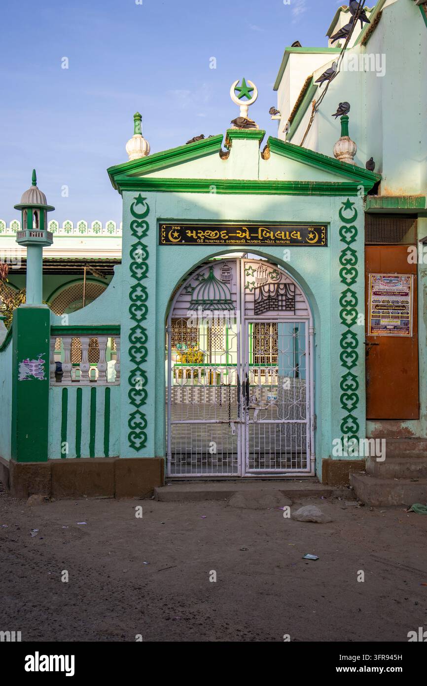 Une porte peinte en vert ornée d’un croissant et d’une étoile mène à une petite mosquée de quartier, Gujarat, Mandvi, Inde Banque D'Images