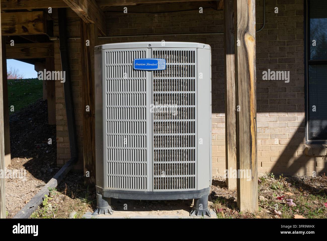 L'unité de condensation et le compresseur d'un climatiseur ancien ont été réparés par un technicien HVAC certifié Banque D'Images