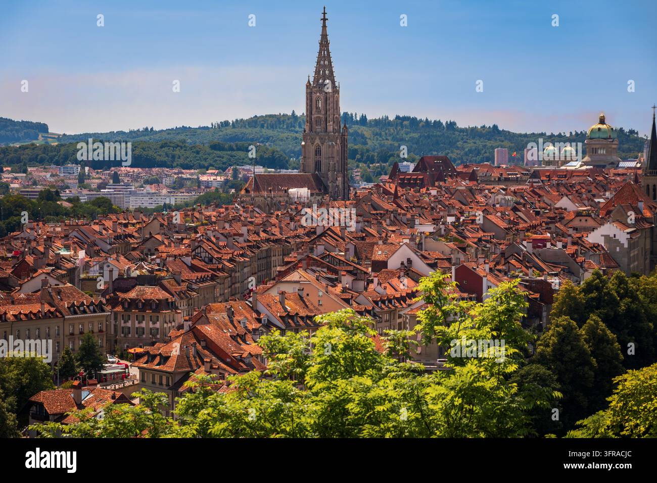 Flèche gothique de la cathédrale du Monastère de Berne sur les toits en tuiles de terre cuite de la vieille ville en grès médiéval ou paysage urbain de l'Altstadt à Berne, Suisse Banque D'Images