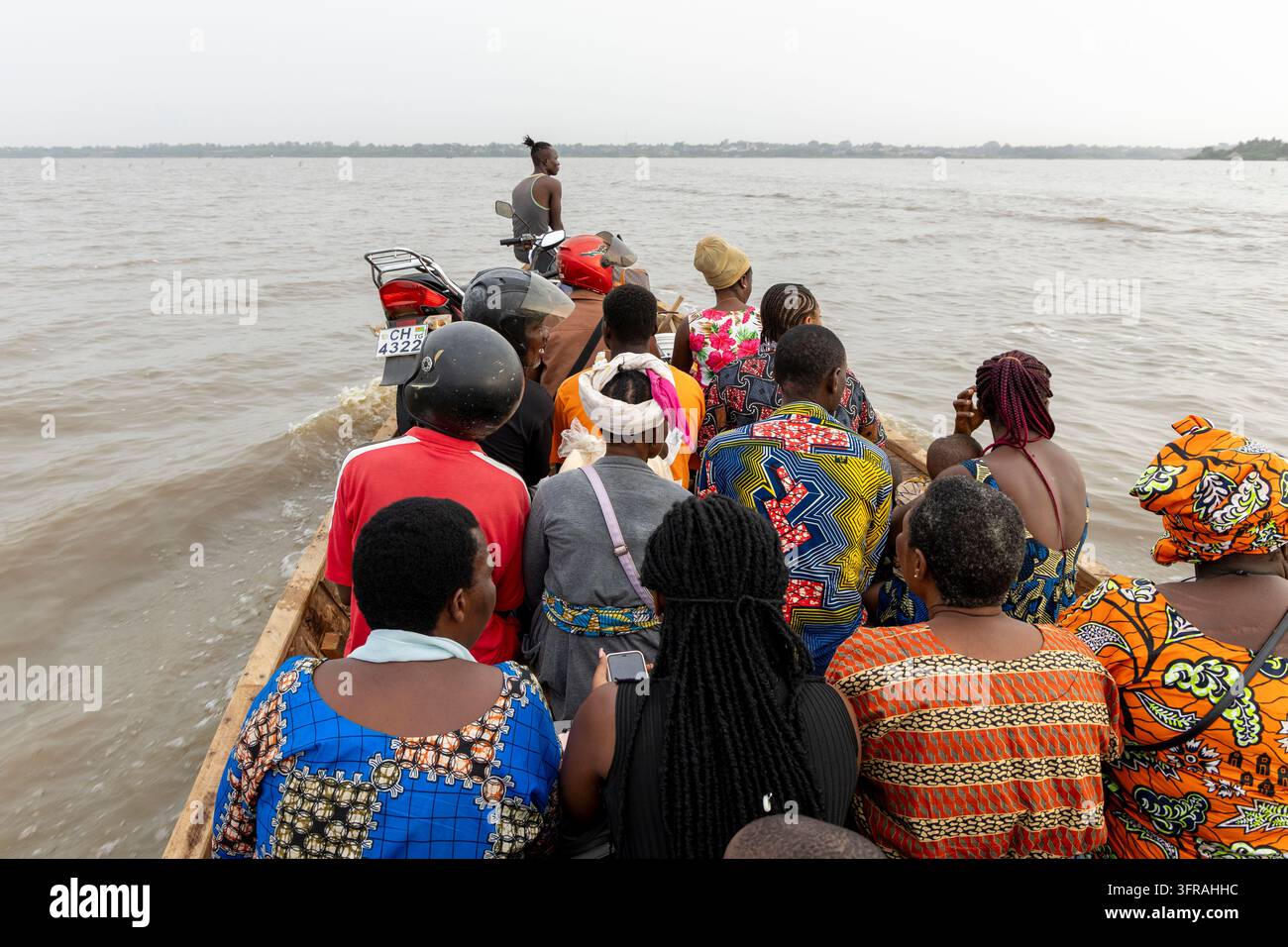 Des passagers et une moto encombrent une pirogue en bois traversant le lac, Région Maritime, Togoville, Togo Banque D'Images