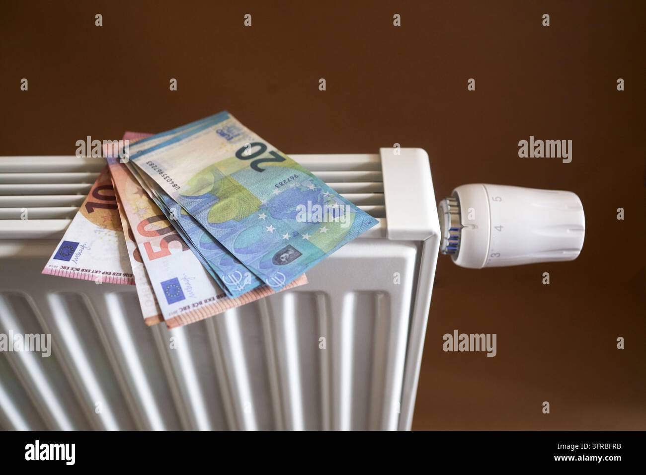 Billets en euros sur un radiateur symbolisant les coûts de chauffage et la crise énergétique Banque D'Images