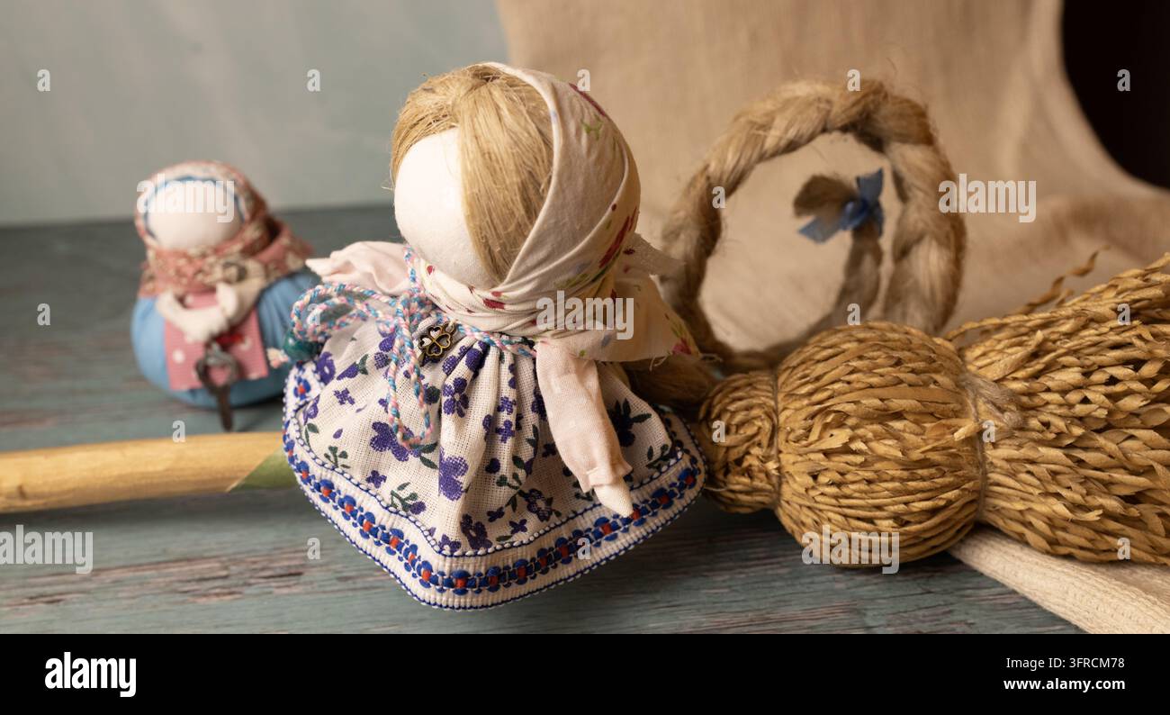 Poupée Motanka ukrainienne traditionnelle en robe fleurie avec blé et décorations populaires rustiques Banque D'Images