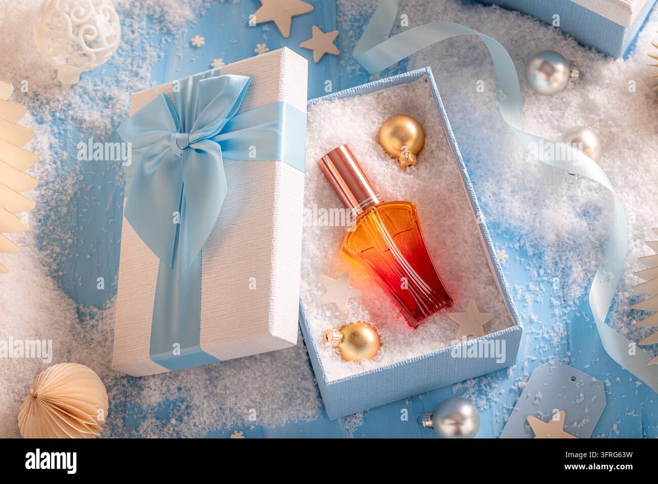 Bouteille de parfum magnifique offerte pendant la saison froide de l'hiver. Le parfum au flacon unique est présenté dans une boîte cadeau élégante. Banque D'Images