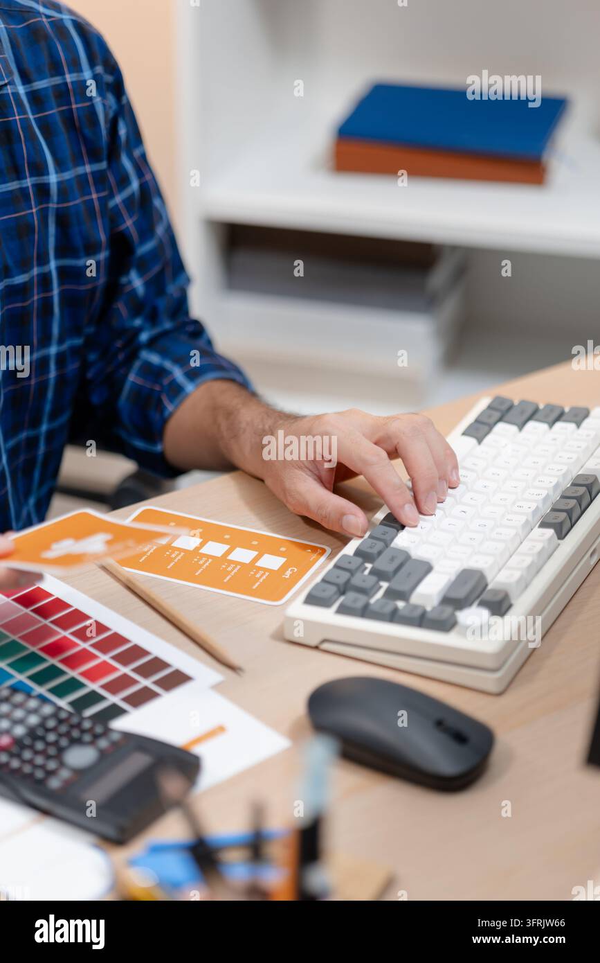Concepteur créatif planifiant des concepts UX/UI avec des palettes de couleurs, des éléments d'interface et des matériaux de conception pour des expériences web et mobiles réactives. Banque D'Images