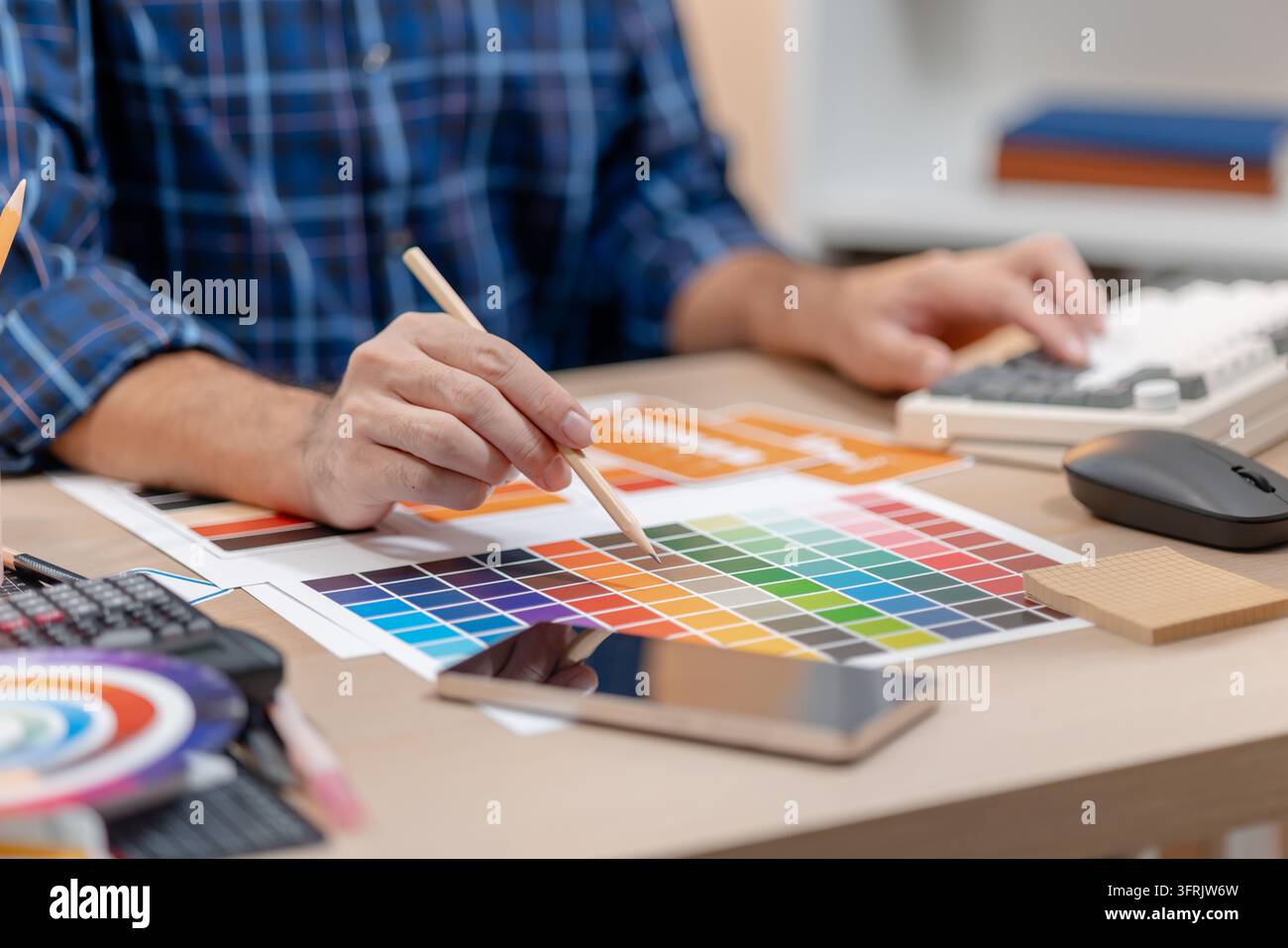 Concepteur créatif planifiant des concepts UX/UI avec des palettes de couleurs, des éléments d'interface et des matériaux de conception pour des expériences web et mobiles réactives. Banque D'Images