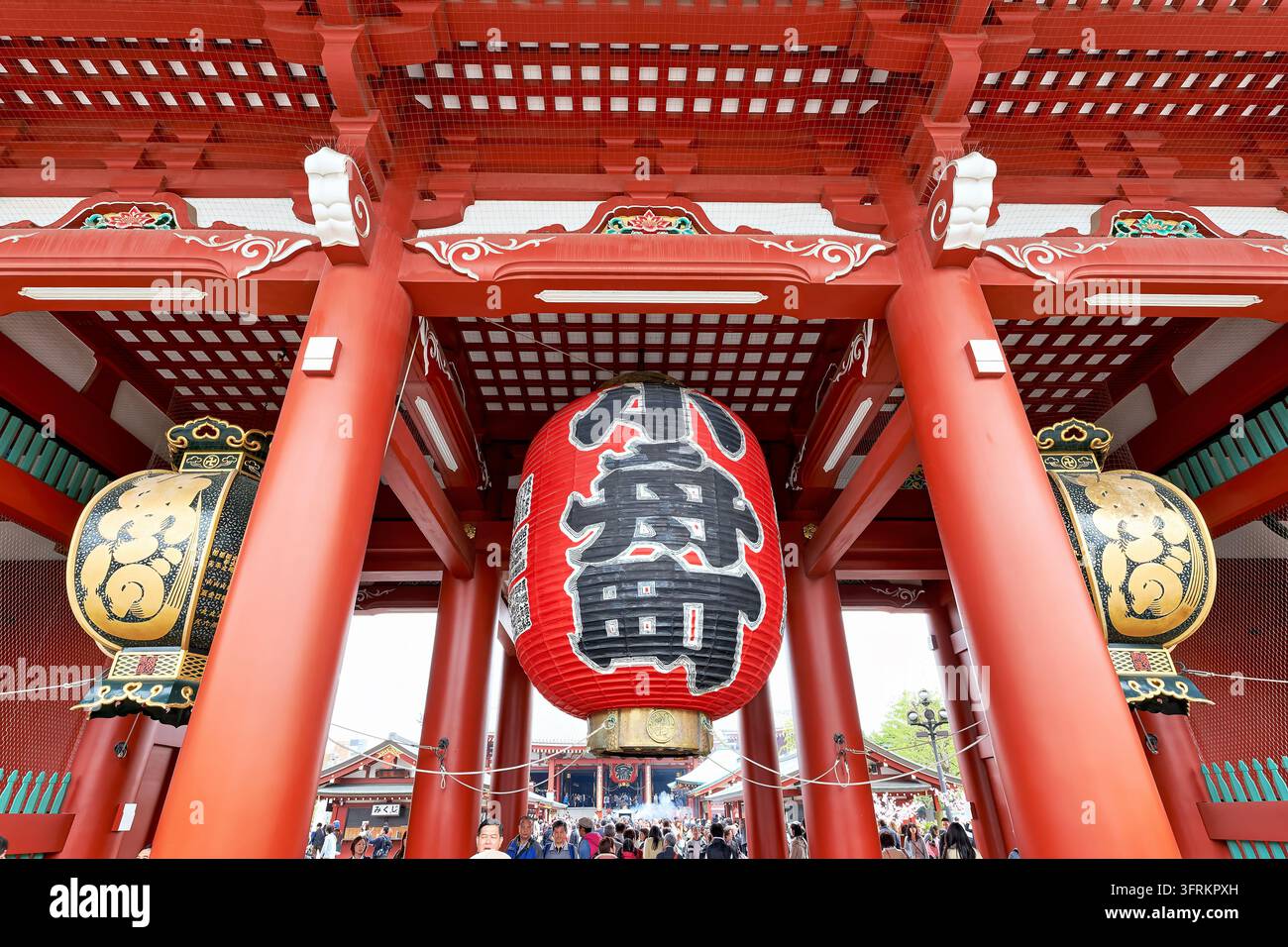 Vue en contre-plongée à travers la porte intérieure du temple bouddhiste d'Asakusa vers le hall principal, avec des visiteurs et de la fumée d'encens au printemps, Japon Banque D'Images