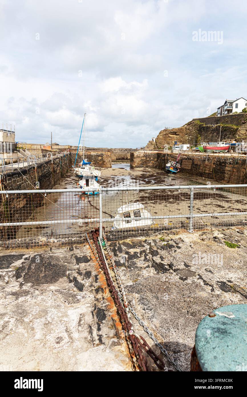 Portreath Harbour à marée basse à Portreath, Cornouailles, Angleterre, Royaume-Uni. Des bateaux de pêche traditionnels sont amarrés dans le bassin historique du port Banque D'Images