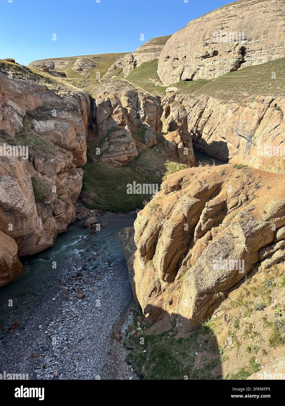 Cachette de roche rouge : un ruisseau dévale les parois de grès du canyon d'Ulken Kuljabashi, au Kirghizistan Banque D'Images