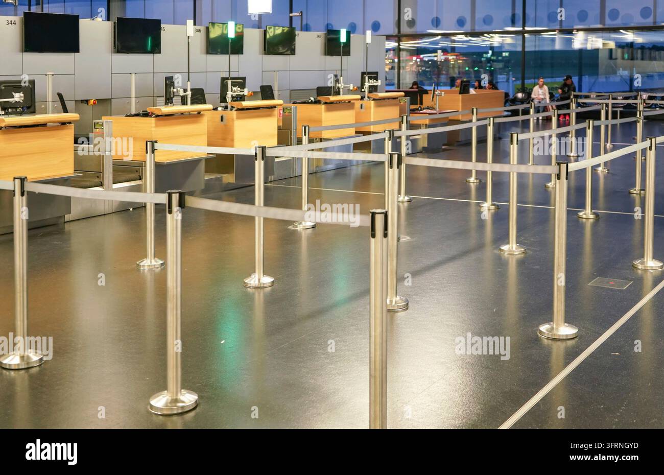 Schwechat, Autriche - 22 avril 2019 : zone d'attente vide divisée par des limites de bande aux comptoirs d'enregistrement de l'aéroport de Vienne, floue à l'arrière-plan des personnes Banque D'Images