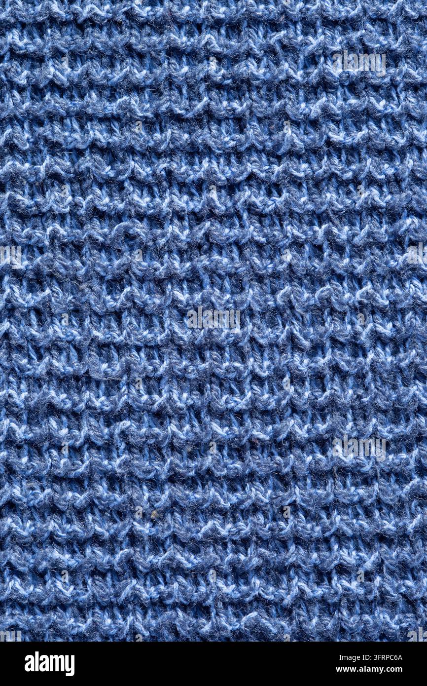 Grossissement des coutures sur un fond de pull en laine fait main bleu. Concept de vêtements automne-hiver Banque D'Images