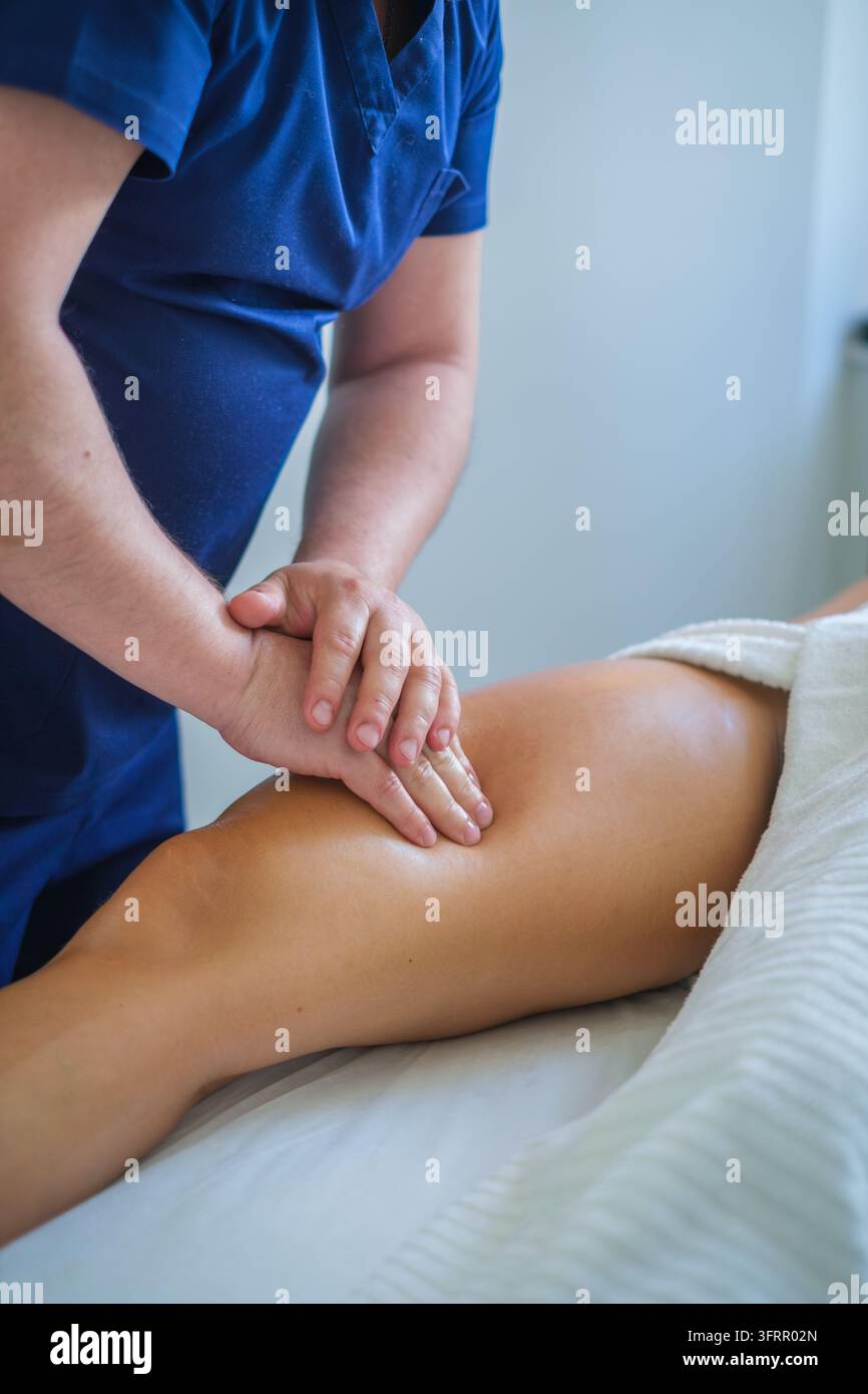 Dans un salon de beauté, ce service professionnel propose un massage des cuisses, un massothérapeute, un massage des jambes, un massage de la partie supérieure des cuisses, un massage thérapeutique et Banque D'Images