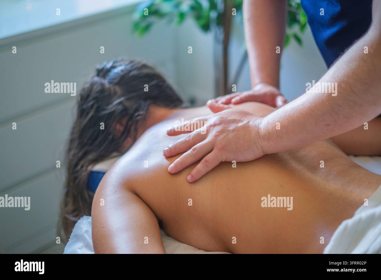 Service de salon de massage professionnel mettant en vedette un massage du dos, un massothérapeute, un massage thérapeutique, une cliente féminine, une femme et le massage pendant un Banque D'Images