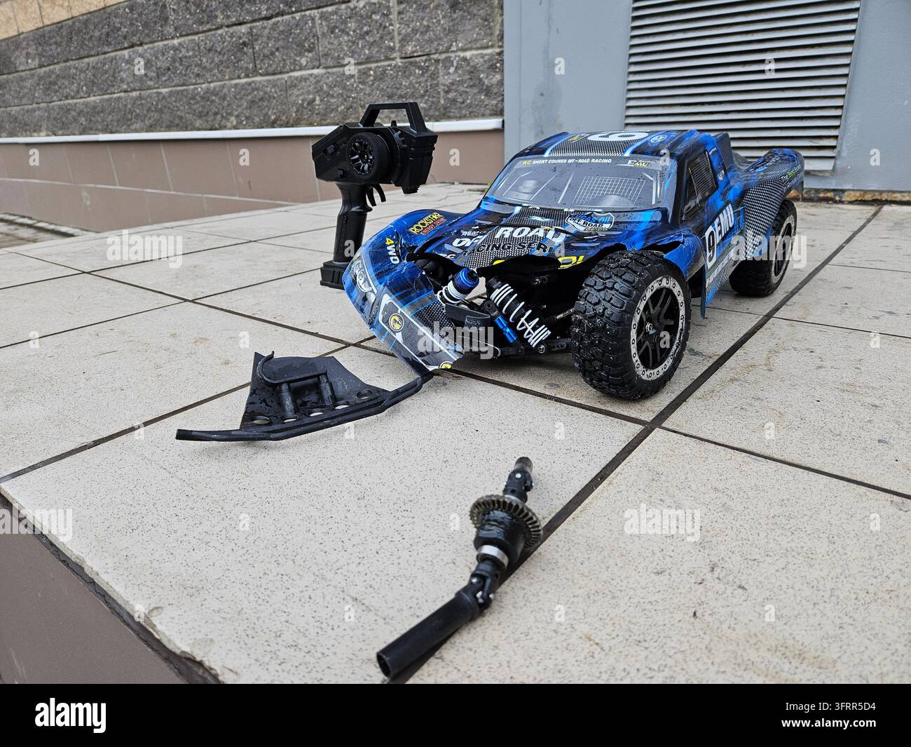 Moscou - 15 nov 2024 : Voiture de drift RC bleue et noire avec une extrémité avant cassée. La voiture est sur un sol en ciment Banque D'Images
