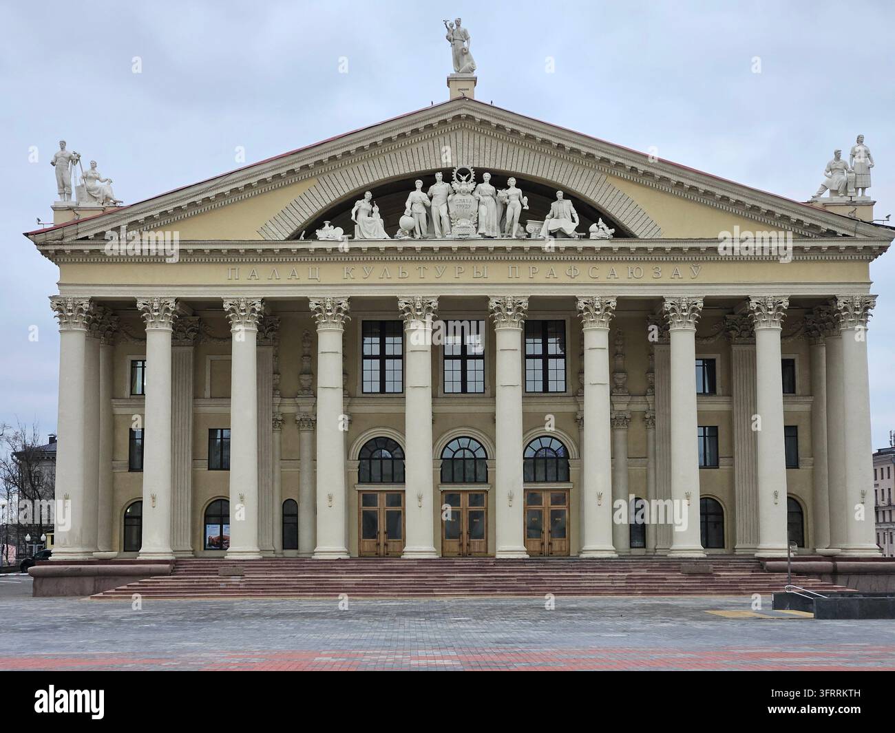 MINSK - 25 MARS 2025 : Un grand bâtiment, le Palais de la Culture des Syndicats, avec de nombreuses colonnes et statues. Le bâtiment est blanc et présente de nombreux détails Banque D'Images
