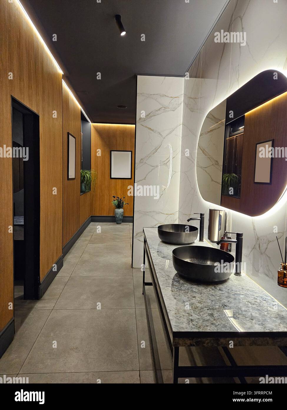 Moscou - 6 avr. 2025 : Une salle de bain avec deux lavabos et un miroir. Le miroir est entouré d'une bordure lumineuse. La salle de bain est propre et bien éclairée Banque D'Images