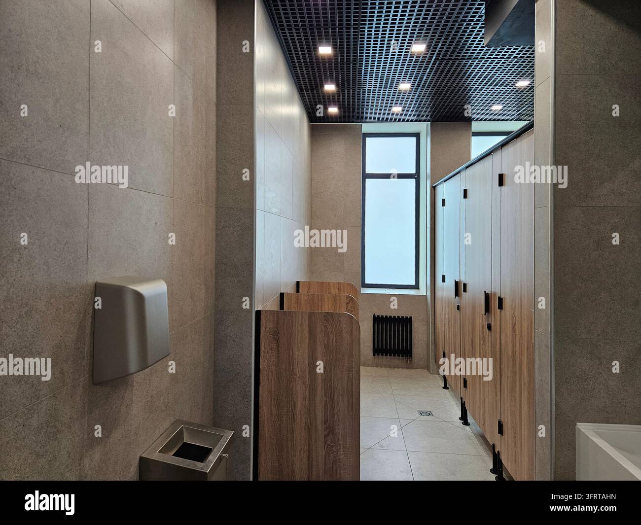 Moscou - 25 août 2025 : Salle de bains avec une fenêtre et un mur équipé d'un sèche-mains. La salle de bains est vide dans une école rénovée lors de la journée portes ouvertes Banque D'Images