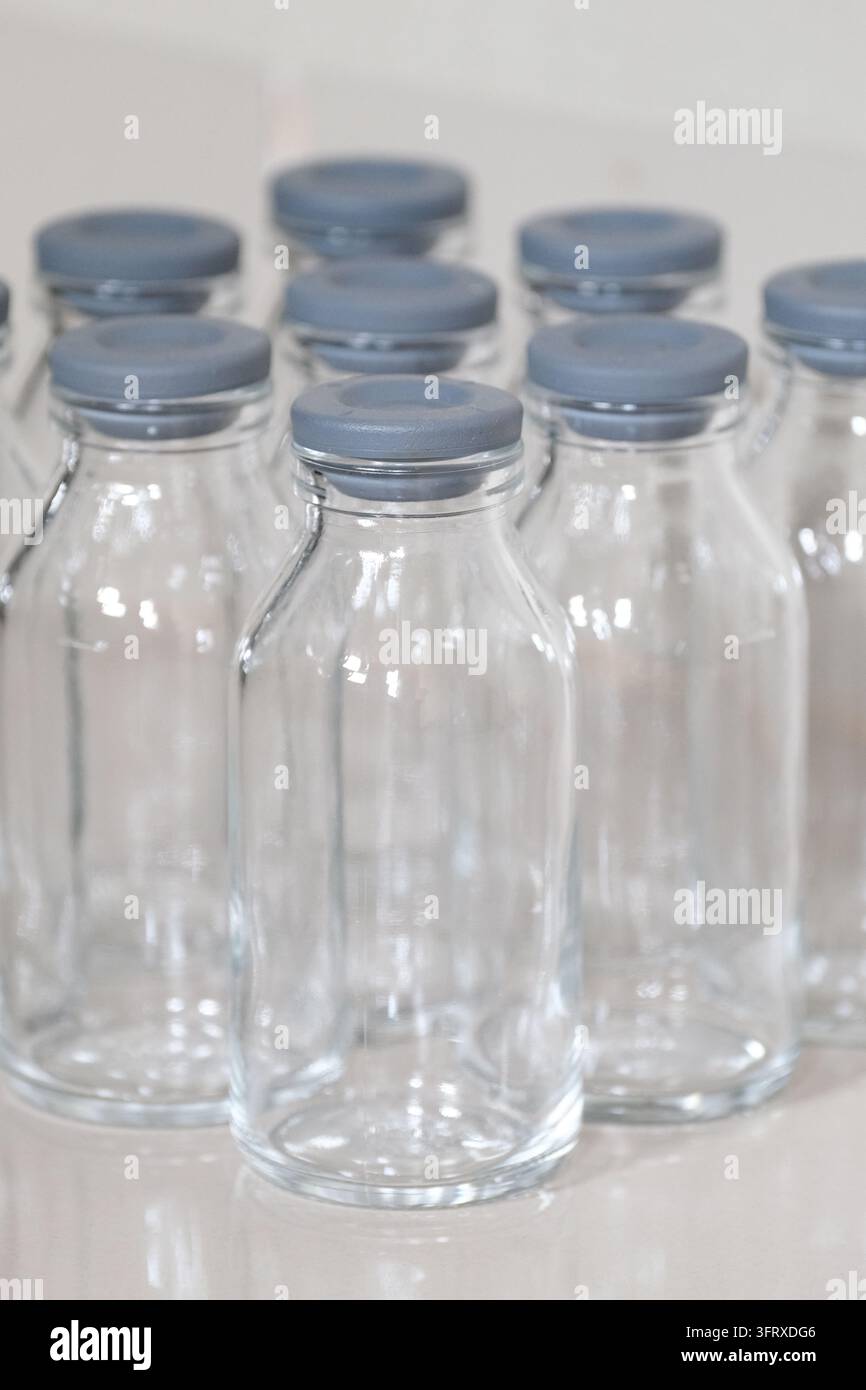 Gros plan de bouteilles vides en verre transparent avec bouchons en caoutchouc gris Banque D'Images