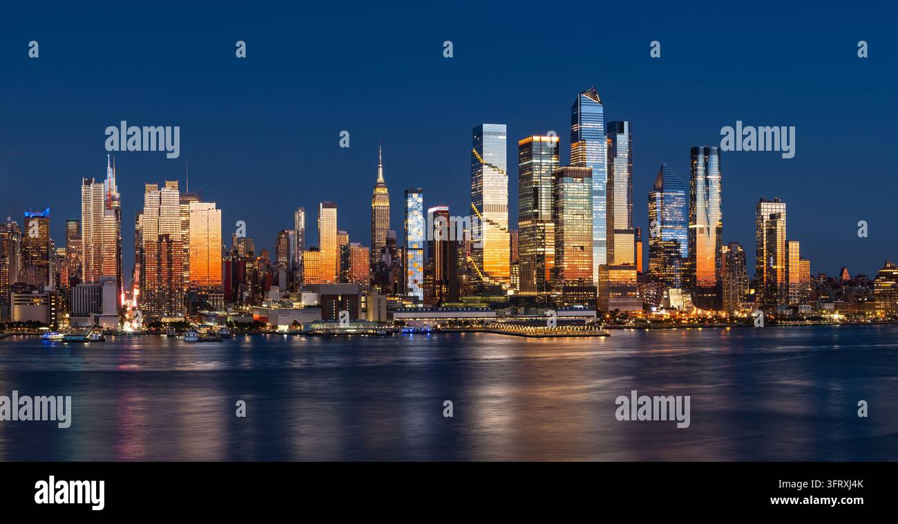 Vue nocturne de New York City sur la ligne d'horizon de Midtown Manhattan depuis l'autre côté du fleuve Hudson, avec les gratte-ciel de Hudson Yards illuminés par la lumière du coucher de soleil. États-Unis Banque D'Images