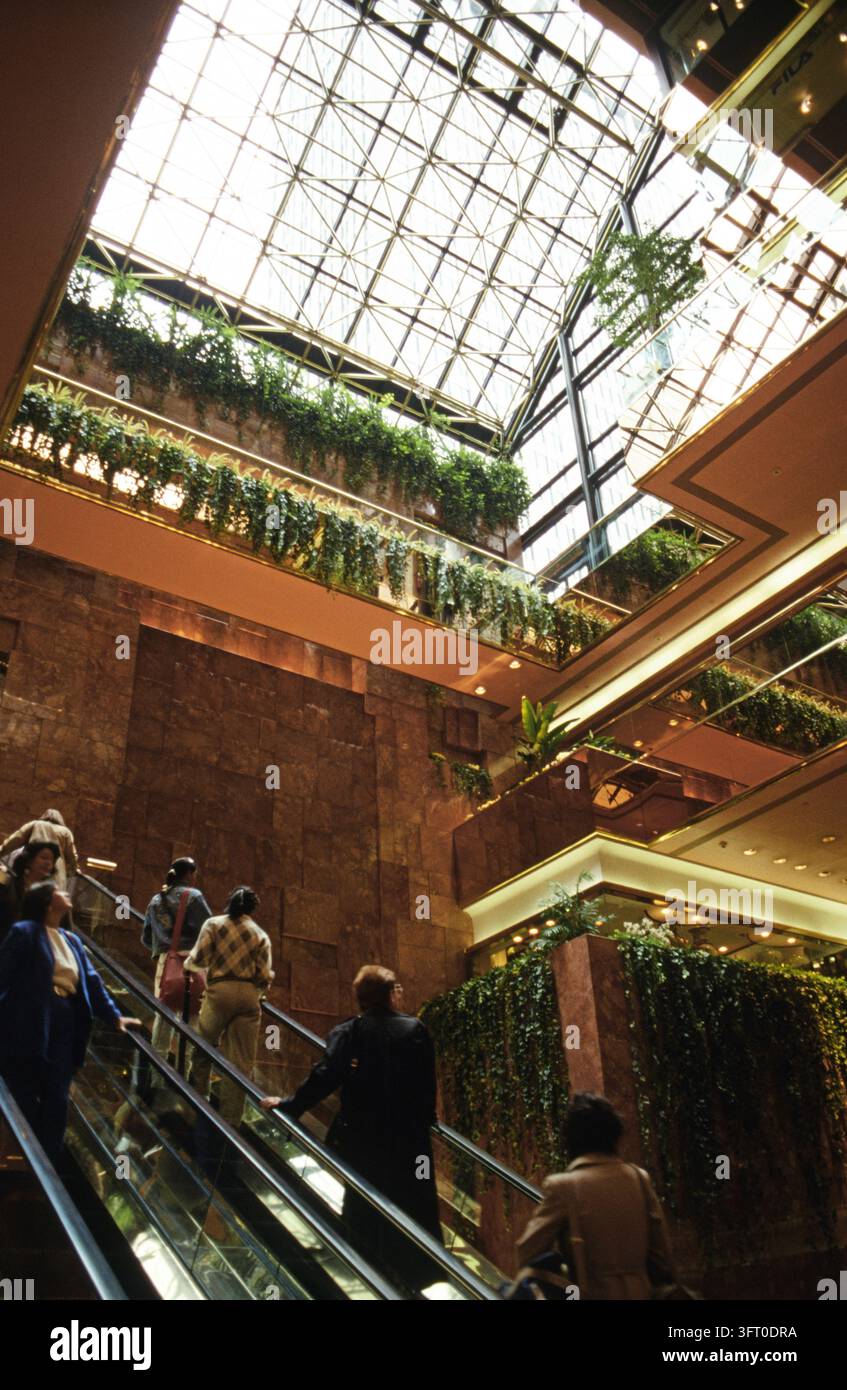 L'atrium intérieur du Trump Tower, situé sur la 5e avenue à New York. Une vue du toit en verre géométrique et des plantes suspendues au-dessus des escaliers mécaniques. Manhattan, New York, États-Unis, 1987 Banque D'Images
