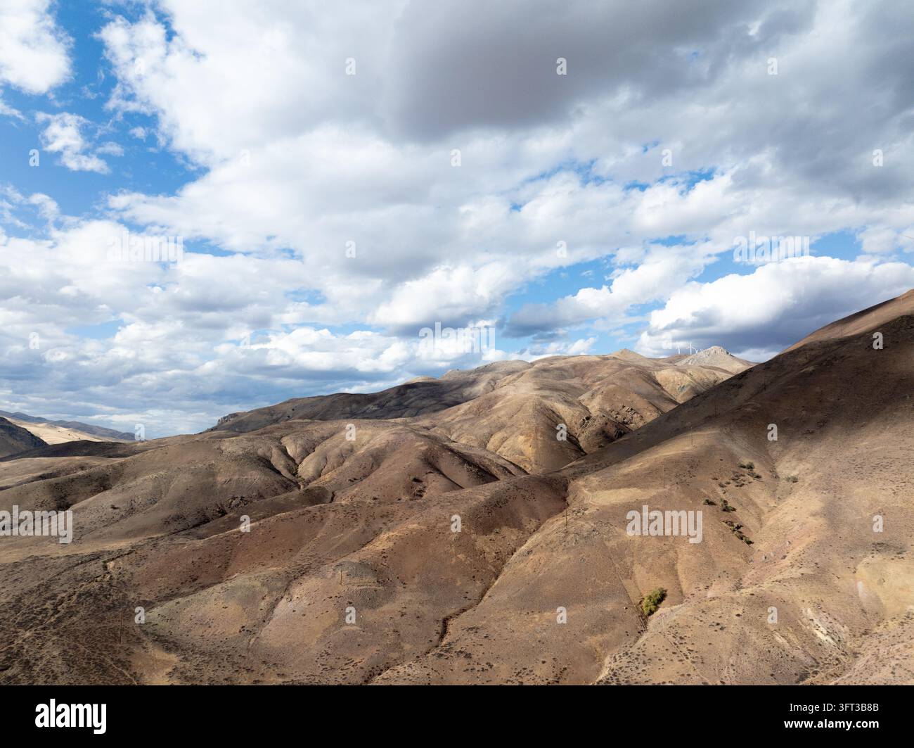 Les crêtes ensoleillées des montagnes s'étendent sous des nuages dynamiques Banque D'Images