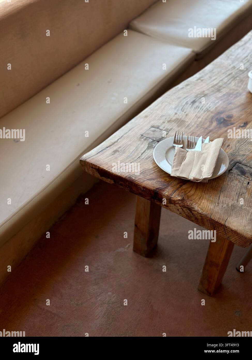 Table basse en bois rustique à côté d'un canapé lounge blanc dans un bar de plage - Image de stock capturée avec un smartphone