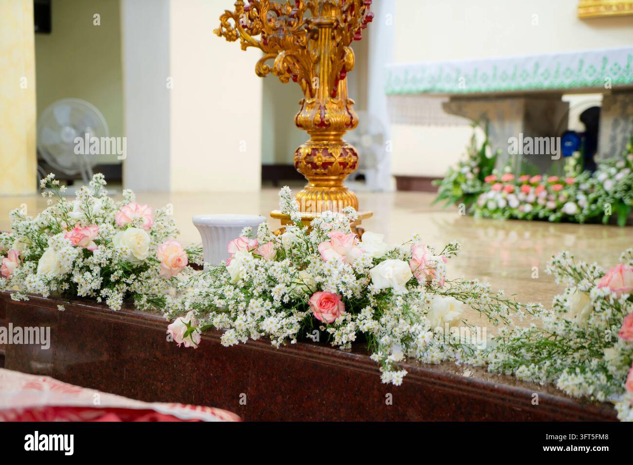 Arrangement de fleurs fraîches de roses blanches et roses sur l'autel de l'église Banque D'Images