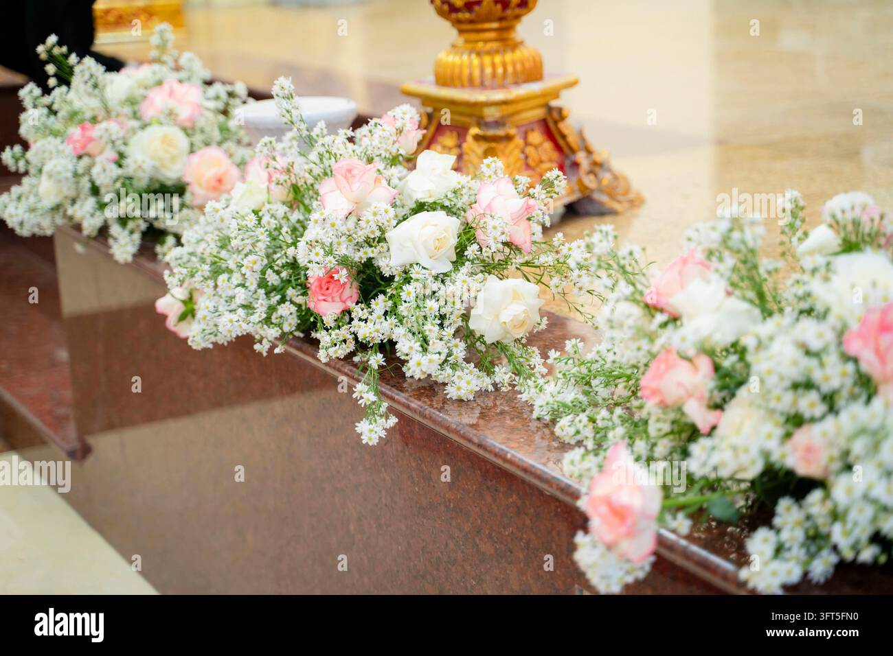 Arrangement de fleurs fraîches de roses blanches et roses sur l'autel de l'église Banque D'Images
