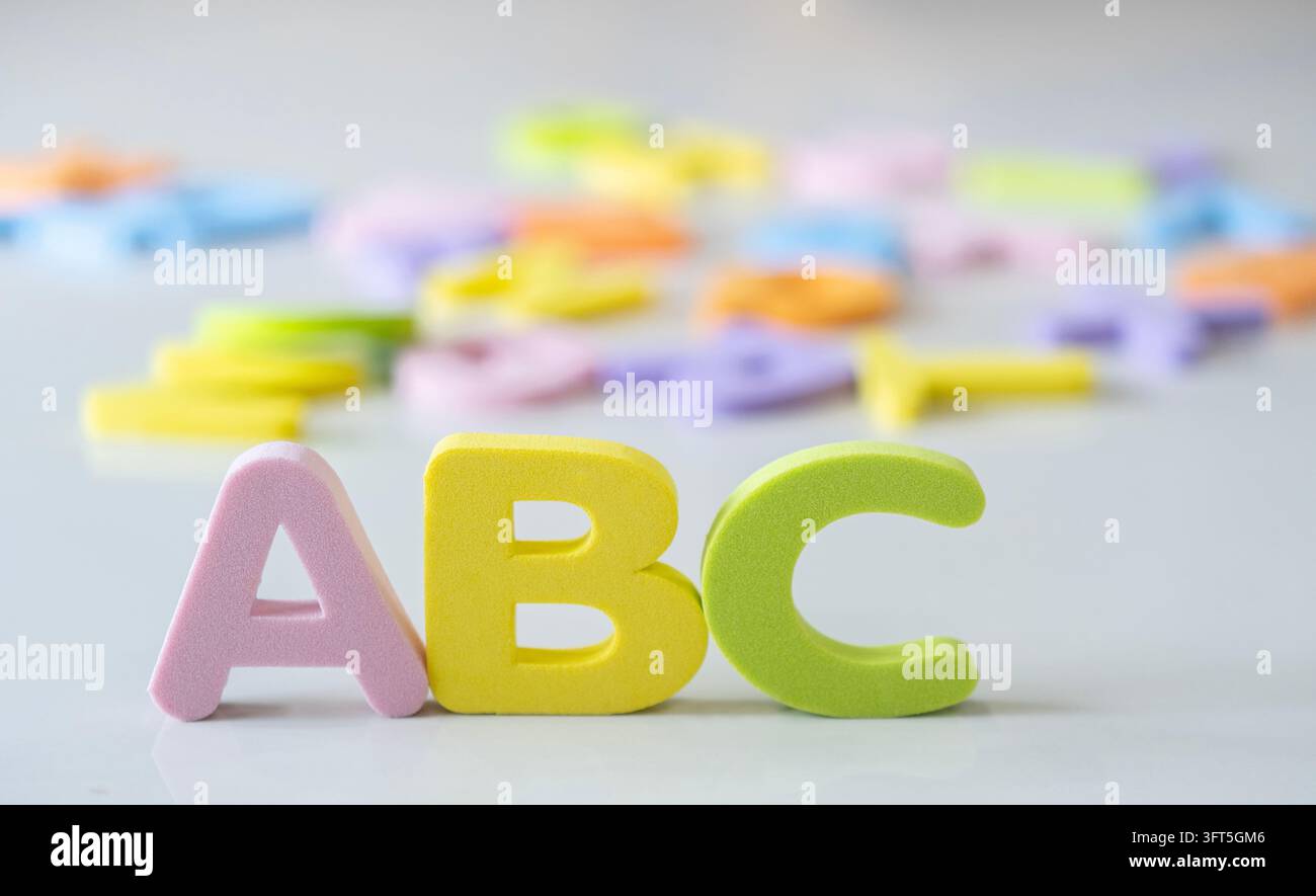 Close up d'un puzzle éducatif ABC pour enfants avec de nombreux alphabets flous sur le sol derrière. Élève heureux pour la rentrée des classes. Enfant apprenant l'alphabet l Banque D'Images