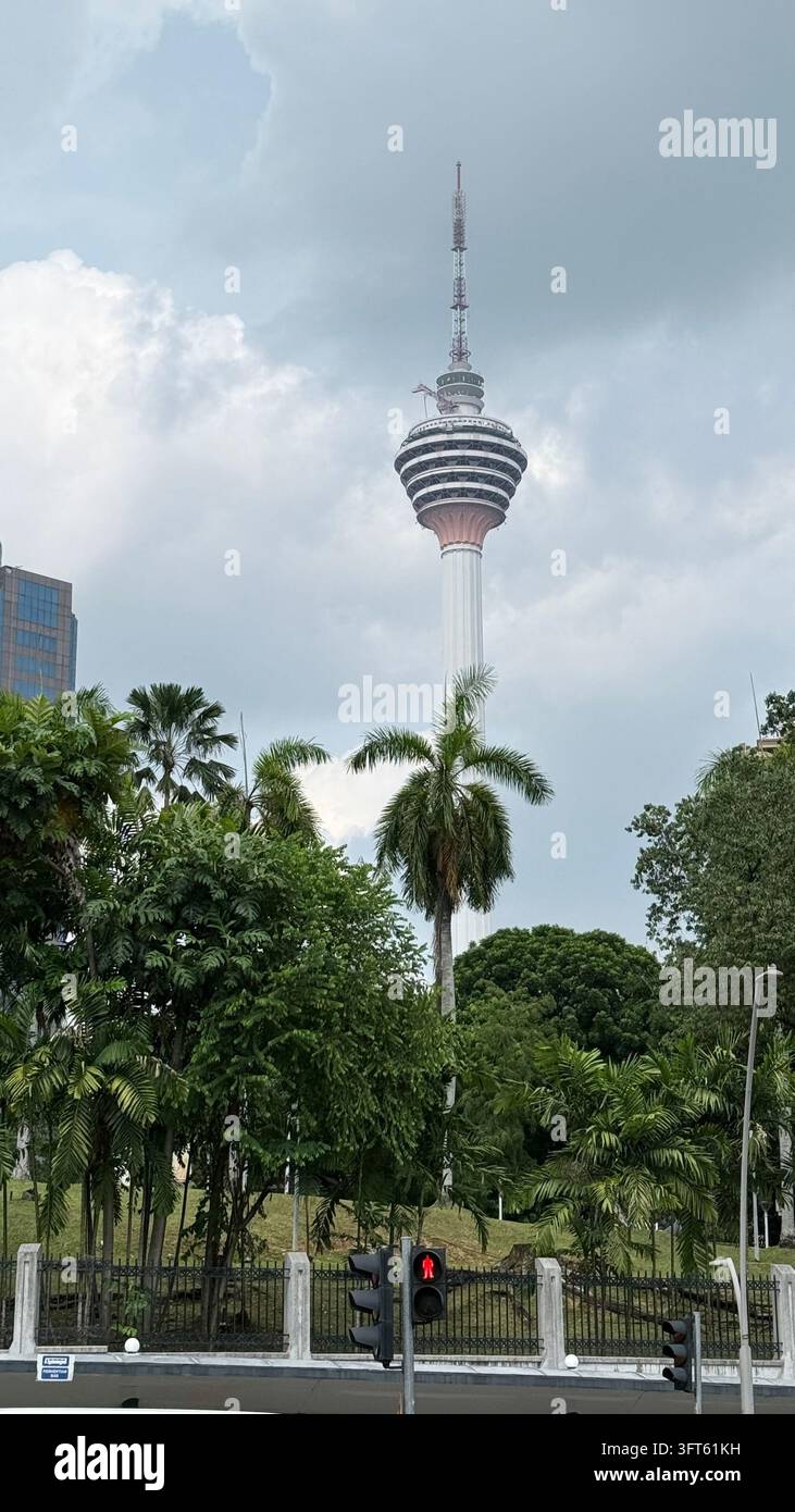 Tour KL s'élevant au-dessus des palmiers tropicaux et de la verdure à Kuala Lumpur - Image de stock capturée avec un smartphone