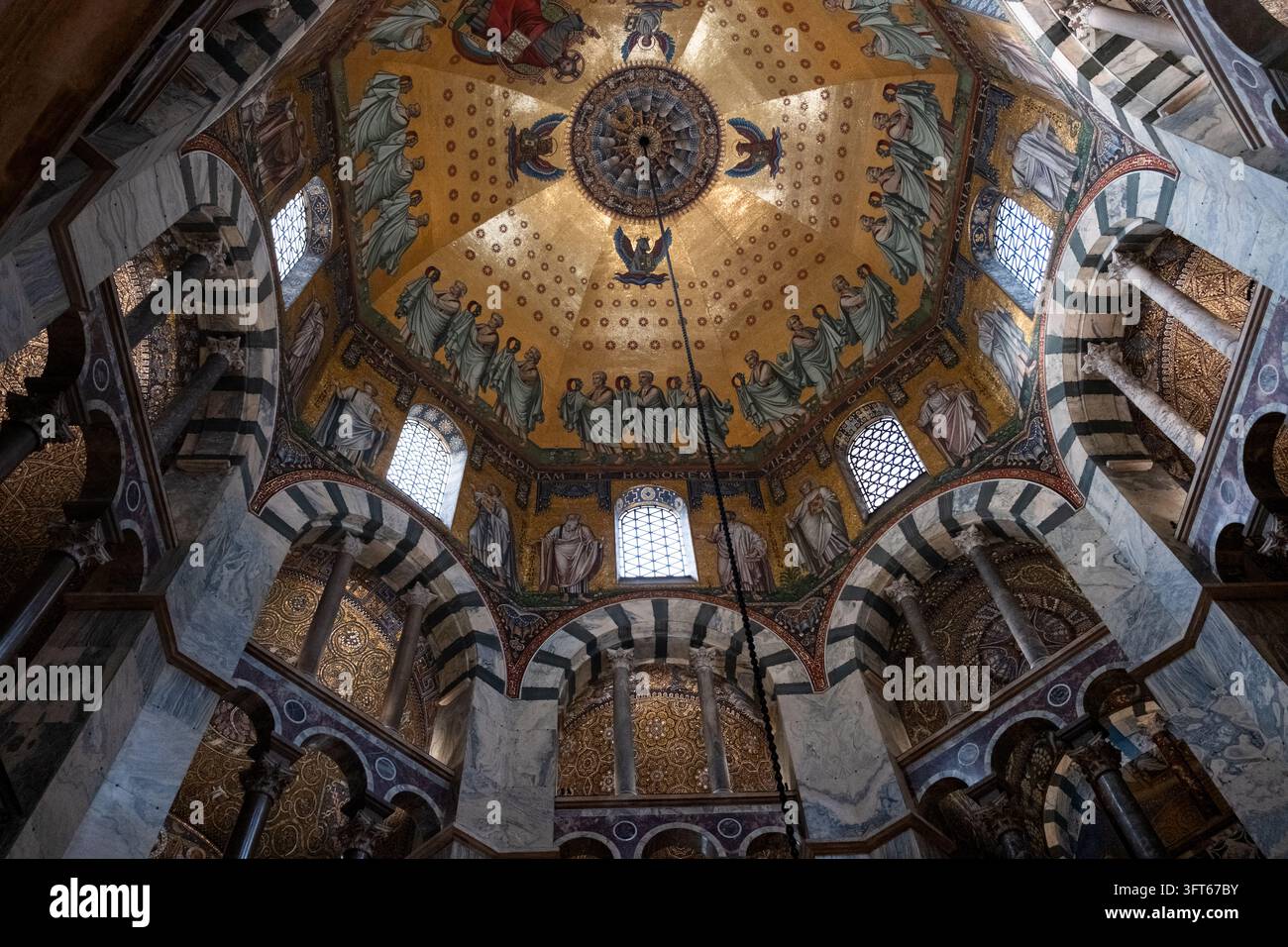 DOME EN MOSAÏQUE OR INTRICATE, CATHÉDRALE D'AACHEN, AACHEN, ALLEMAGNE : Un regard direct vers le haut sur la mosaïque dorée étonnamment détaillée du dôme octogonal du plafond de la cathédrale ancienne historique. INFO : La cathédrale d'Aix-la-Chapelle, le premier site du patrimoine mondial de l'UNESCO en Allemagne, est un chef-d'œuvre architectural carolingien fondé par Charlemagne. Fusionnant des éléments byzantins et gothiques, ce monument historique a servi de lieu de couronnement à trente et un monarques allemands. Banque D'Images