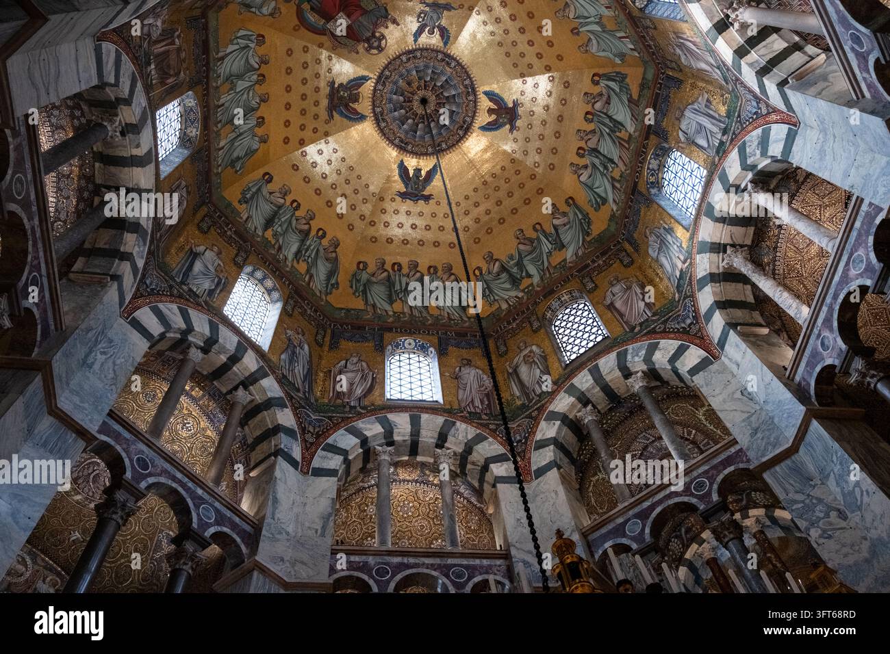 DOME EN MOSAÏQUE OR INTRICATE, CATHÉDRALE D'AACHEN, AACHEN, ALLEMAGNE : Un regard direct vers le haut sur la mosaïque dorée étonnamment détaillée du dôme octogonal du plafond de la cathédrale ancienne historique. INFO : La cathédrale d'Aix-la-Chapelle, le premier site du patrimoine mondial de l'UNESCO en Allemagne, est un chef-d'œuvre architectural carolingien fondé par Charlemagne. Fusionnant des éléments byzantins et gothiques, ce monument historique a servi de lieu de couronnement à trente et un monarques allemands. Banque D'Images