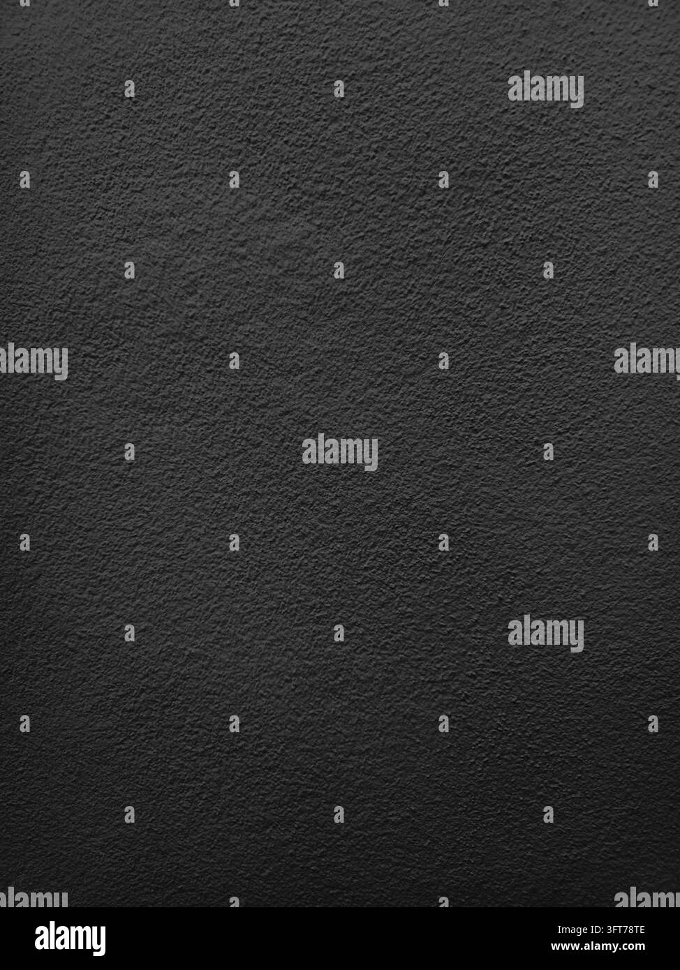 Grossissement d'une texture de mur en béton noir avec une surface peinte rugueuse et des détails légèrement irréguliers, créant un fond abstrait sombre adapté à la moderne - Image de stock capturée avec un smartphone