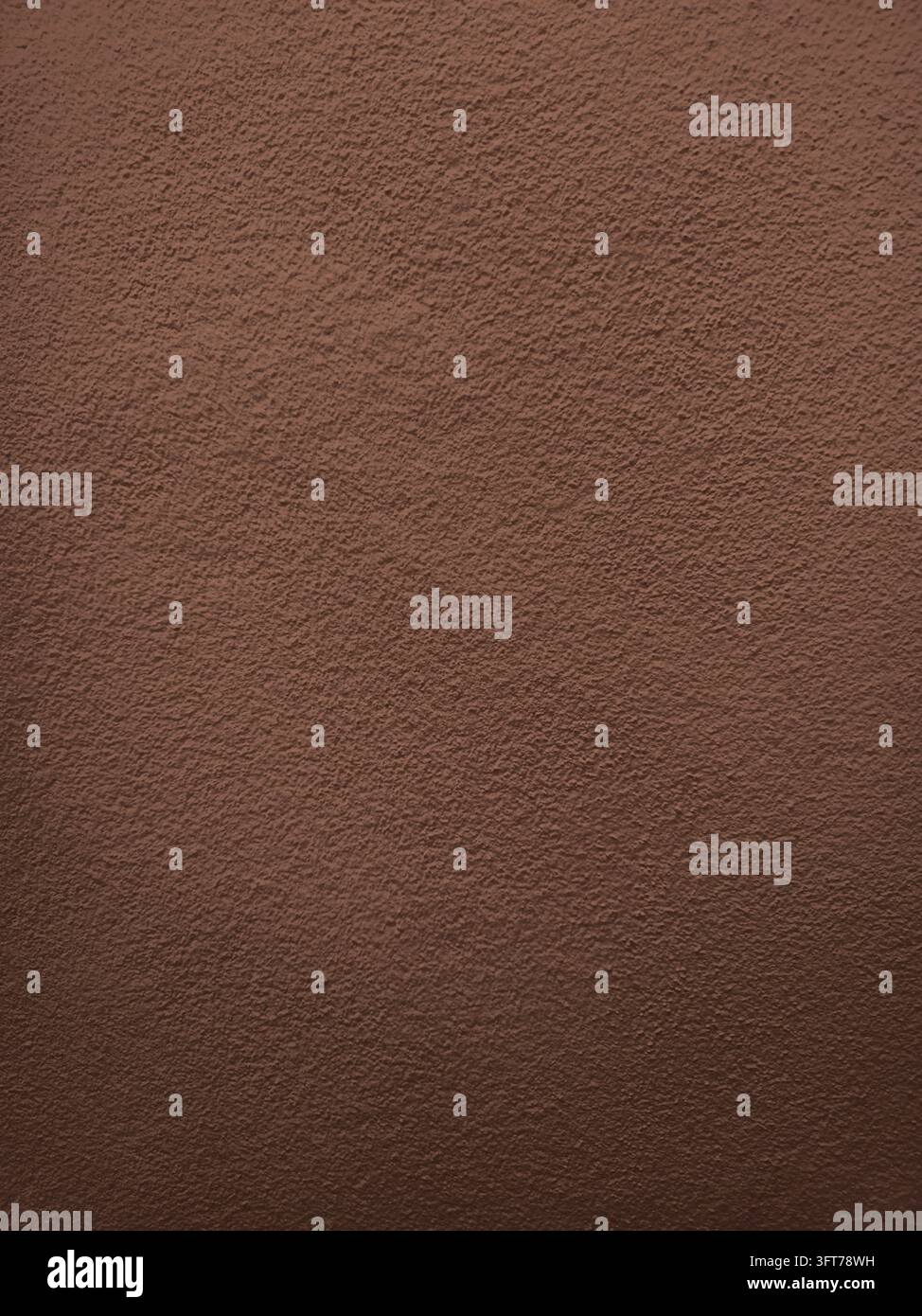 Texture de mur en béton brun chocolat avec une surface en plâtre rugueuse et une variation tonale subtile adaptée aux arrière-plans, à l'architecture, aux intérieurs, aux maquettes - Image de stock capturée avec un smartphone