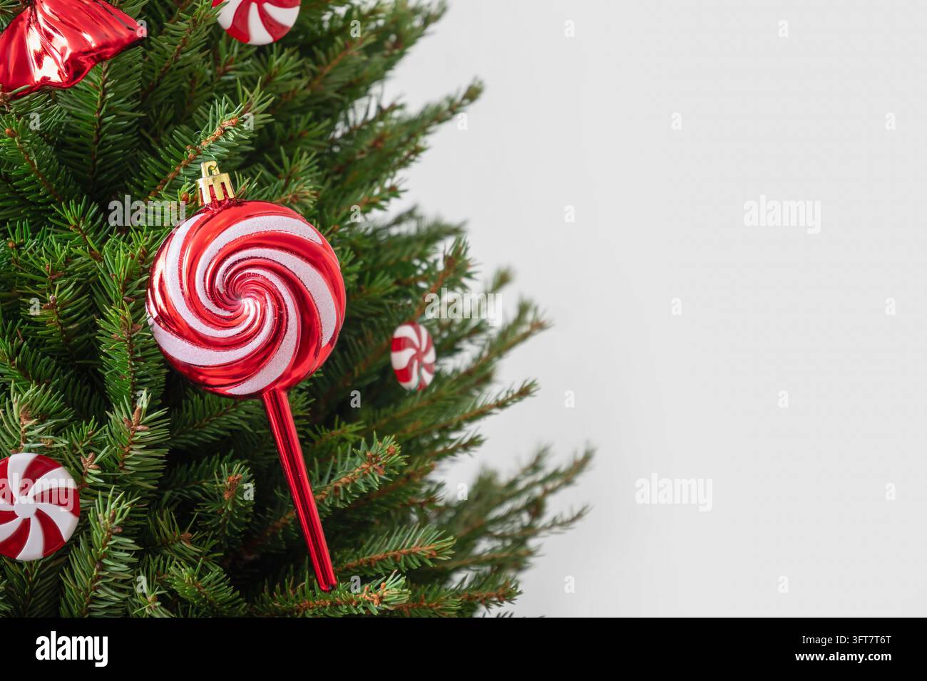 Ornement en sucette rouge et blanche sur un arbre de Noël Banque D'Images