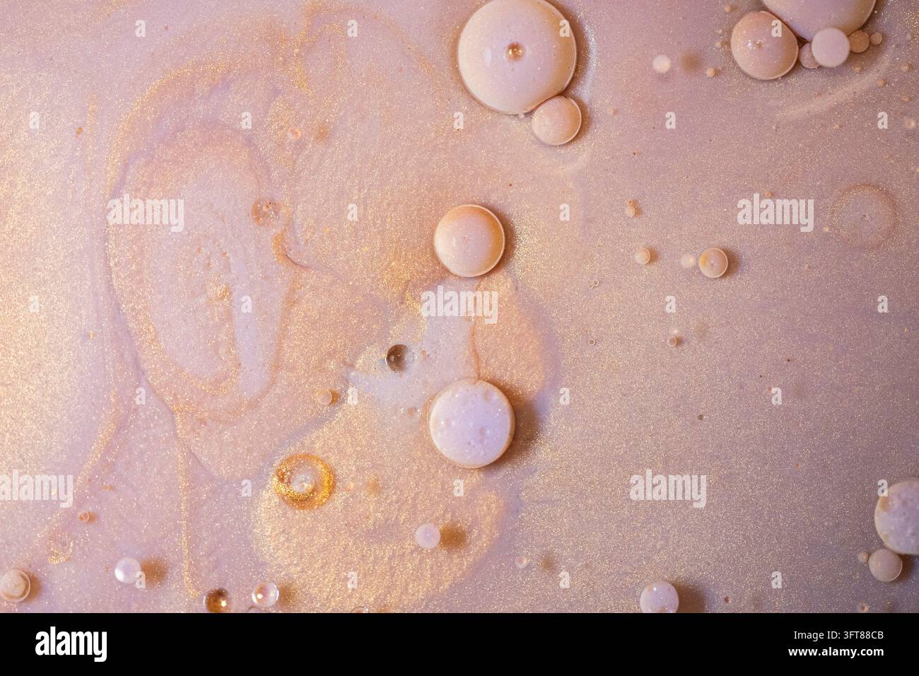 Art fluide or et rose créant un fond abstrait avec une texture scintillante, des tourbillons et des bulles de liquide léger Banque D'Images
