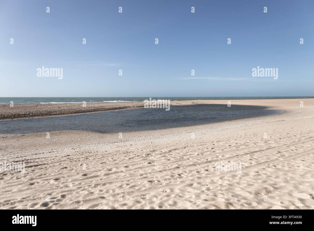 Lagune peu profonde et sereine, immaculée, avec une eau calme reflétant la lumière du jour lors de la marée basse sur une plage tropicale tranquille Banque D'Images
