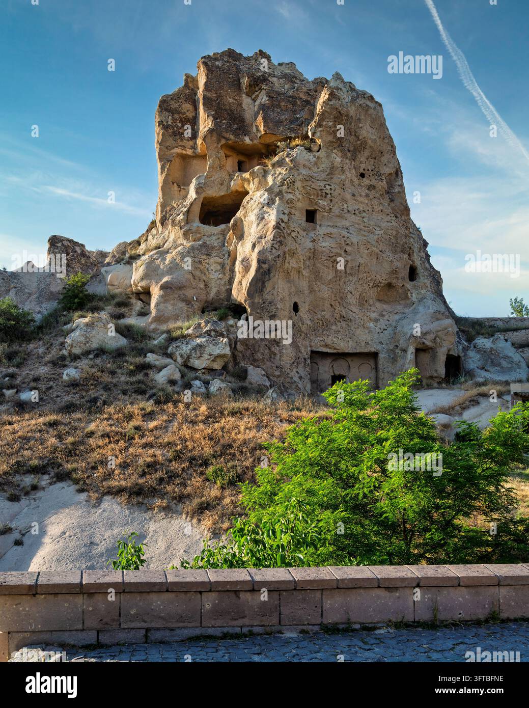 Anciennes habitations creusées dans la roche et cheminées de fées à Cappadoce, Nevsehir, Turquie, présentant des formations rocheuses volcaniques uniques sous un ciel bleu Banque D'Images